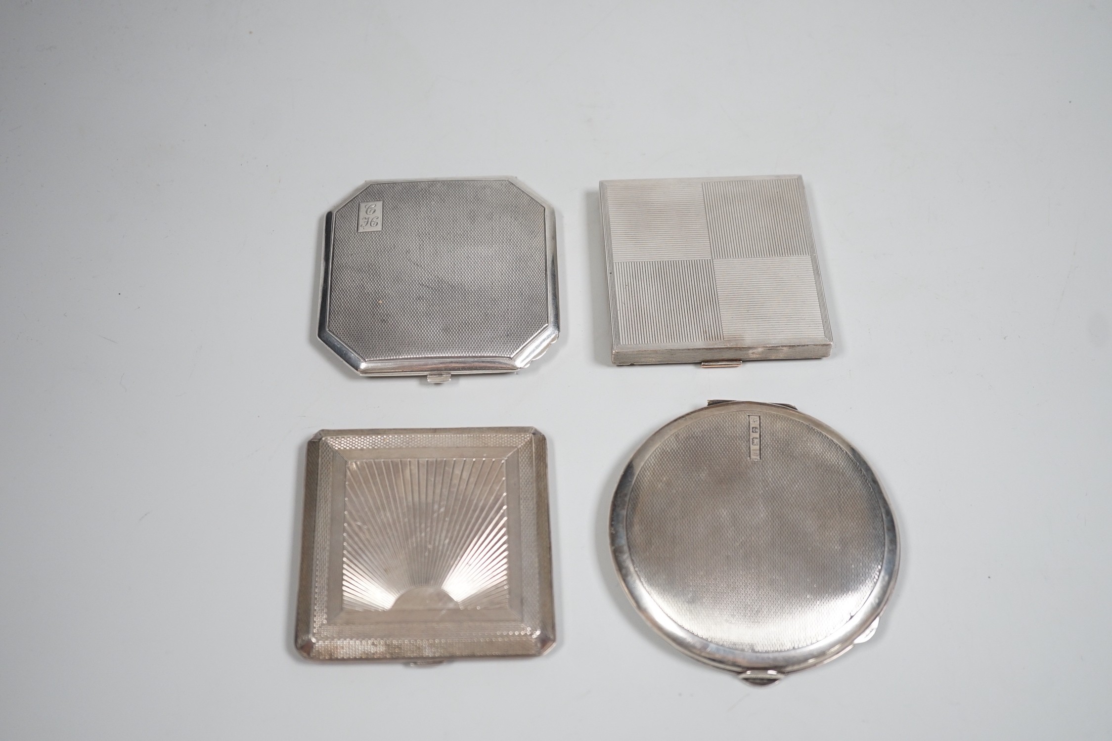 A George V Art Deco silver cigarette case, David Sutton & Sons, London, 1935, 65mm, with leather carrying case, together with three engine turned silver compacts.